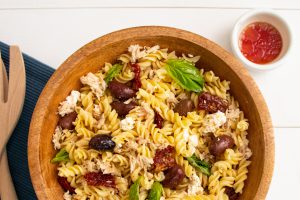 A wooden bowl full of Tuna and Sundried Tomato Pasta Salad